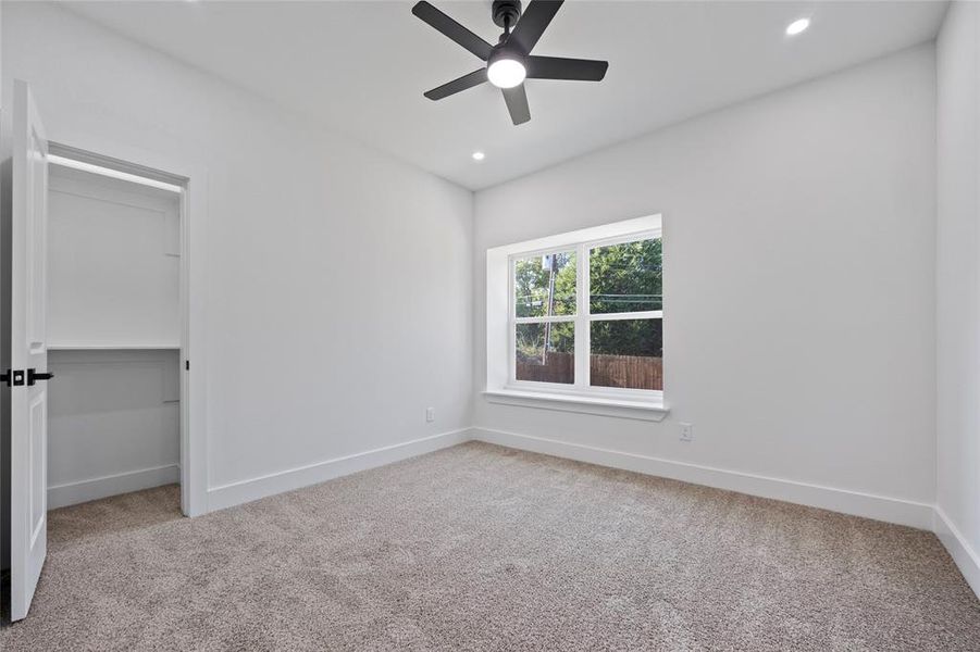 Unfurnished bedroom featuring a closet, light carpet, and ceiling fan