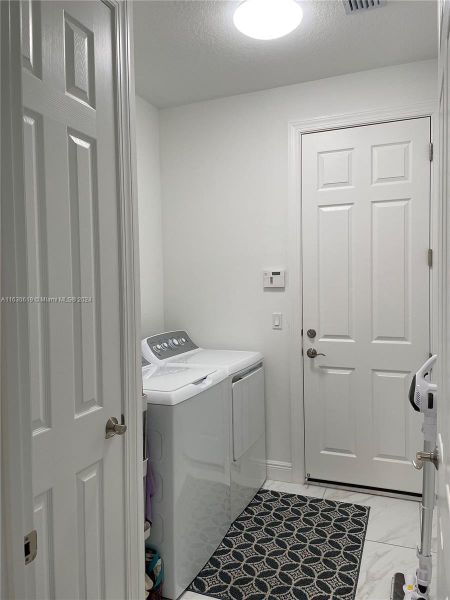 Laundry room and doorway to the garage