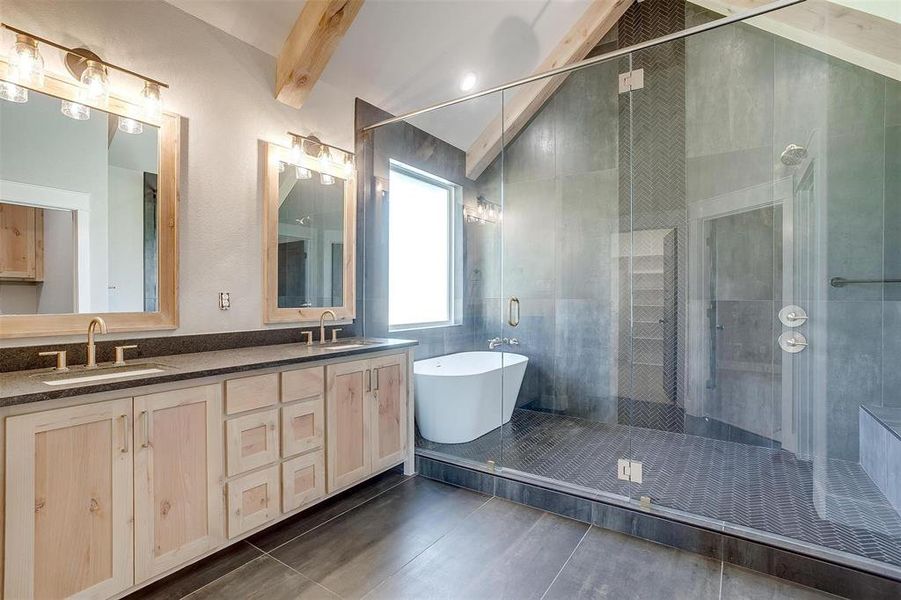 Bathroom featuring beamed ceiling, tile flooring, double sink vanity, and independent shower and bath