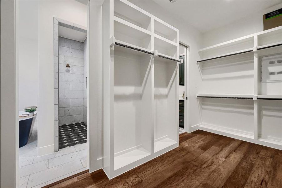 Spacious primary closet connecting to primary bath and laundry room