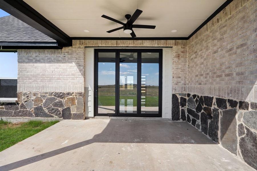 Property entrance with ceiling fan and a patio