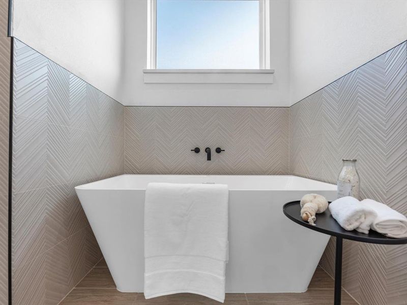 The soaking tub is elegantly designed with perfect natural lighting.