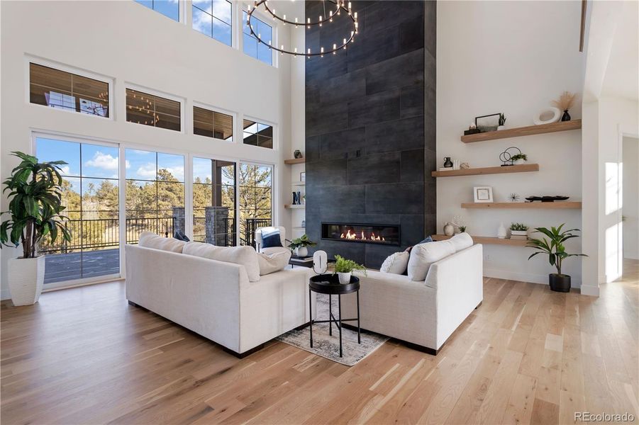 Great Room with 2-story fireplace, nano doors to upper deck & floor to ceiling windows