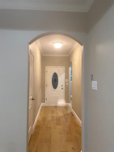 Hallway featuring light hardwood / wood-style flooring and crown molding