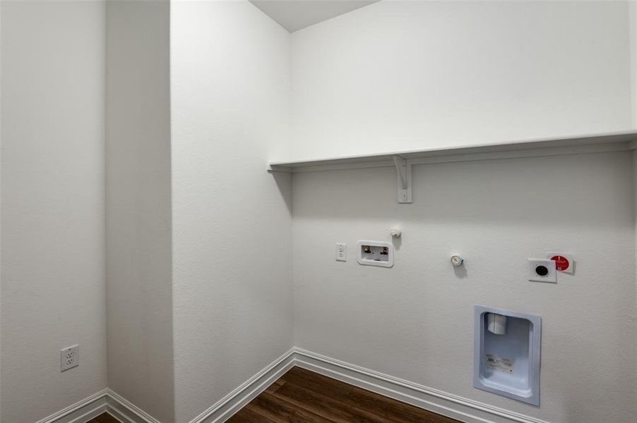 Laundry area with dark wood-type flooring, washer hookup, electric dryer hookup, and hookup for a gas dryer