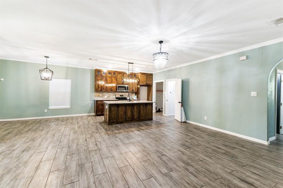 Kitchen featuring hardwood / wood-style floors, pendant lighting, and stainless steel appliances