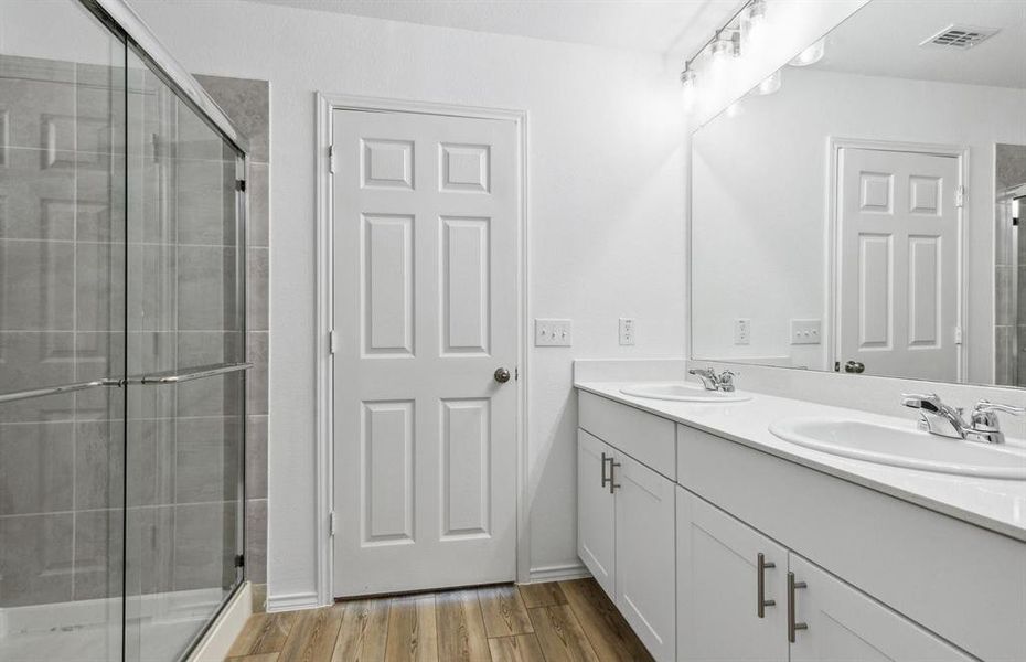 Owner's bath designed with a double vanity and oversized shower *Real home pictured