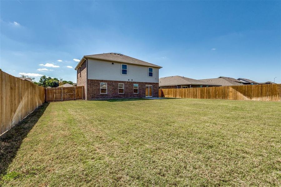 Back of property featuring a yard