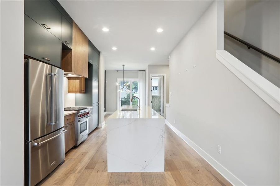 Stunning kitchen with Gas Cooktop, Stainless Refrigerator, Quartz Waterfall countertops.
