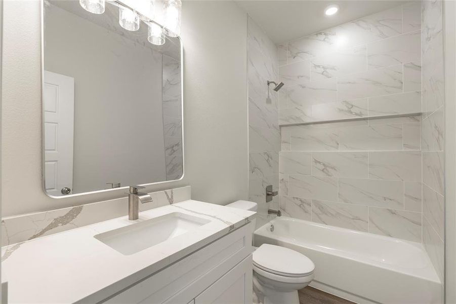 Full bathroom with vanity, toilet, and tiled shower / bath combo