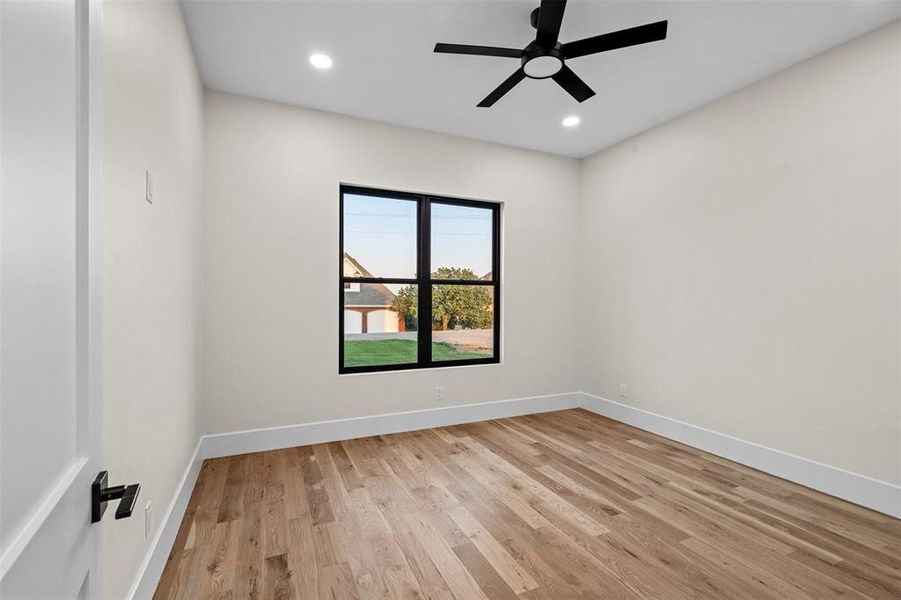 Empty room with ceiling fan and light hardwood / wood-style floors