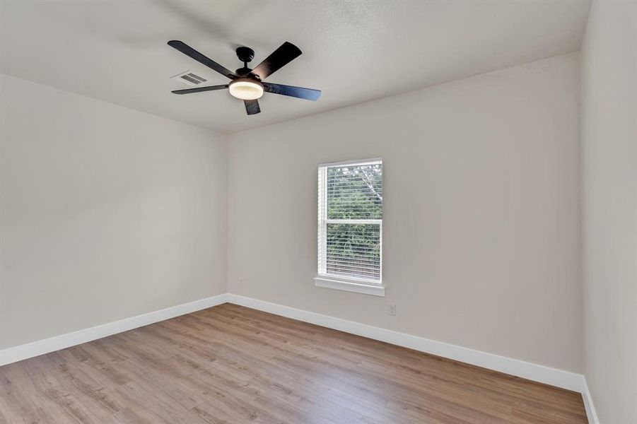 Empty room with ceiling fan and light hardwood / wood-style flooring