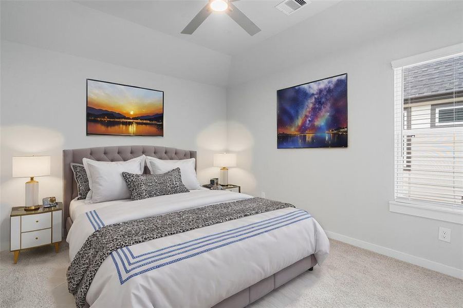 Secondary bedroom features plush carpet, custom paint, ceiling fan, and large window with privacy blinds. This secondary bedroom has its own private access to a secondary bathroom.