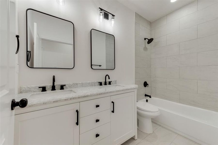 Full bathroom featuring vanity, toilet, and tiled shower / bath combo