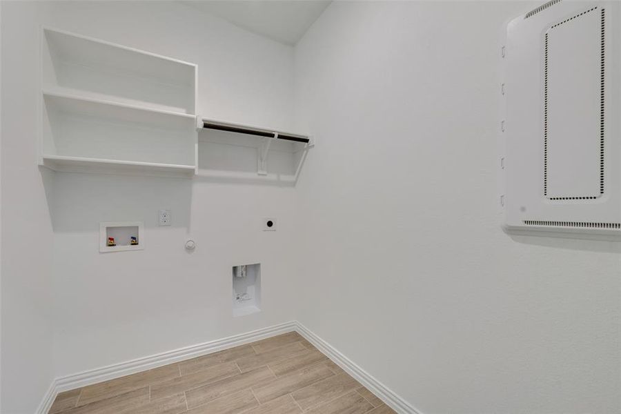 Laundry room featuring hookup for a washing machine, hookup for an electric dryer, gas dryer hookup, and light hardwood / wood-style floors