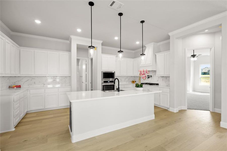 Kitchen featuring ceiling fan, white cabinets, light hardwood / wood-style flooring, and tasteful backsplash