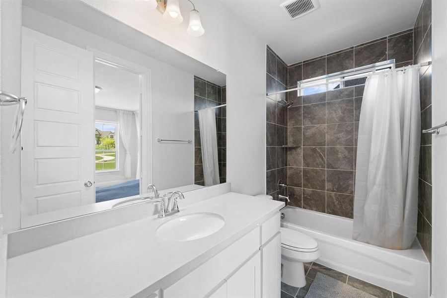 Full bathroom featuring tile flooring, oversized vanity, toilet, and shower / tub combo