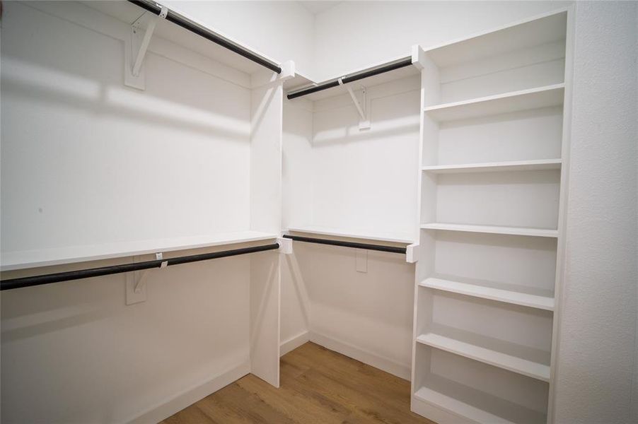 Spacious closet with hardwood / wood-style flooring