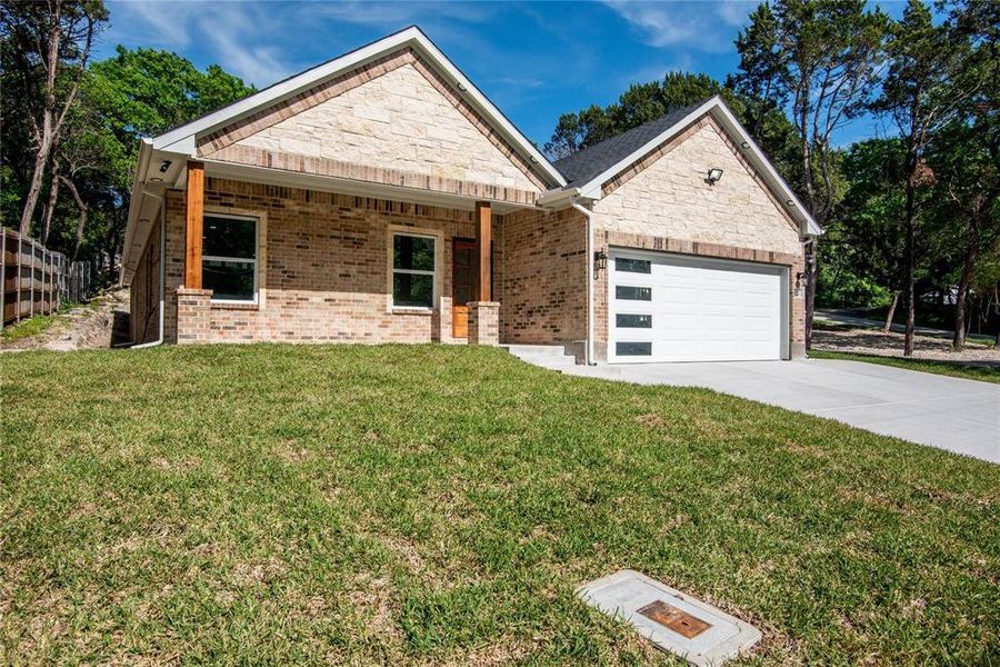 View of front of house featuring a garage and a front yard