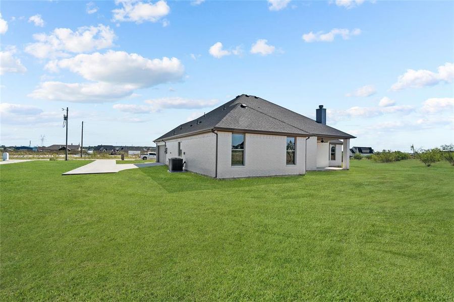 Back of property featuring a yard and central AC