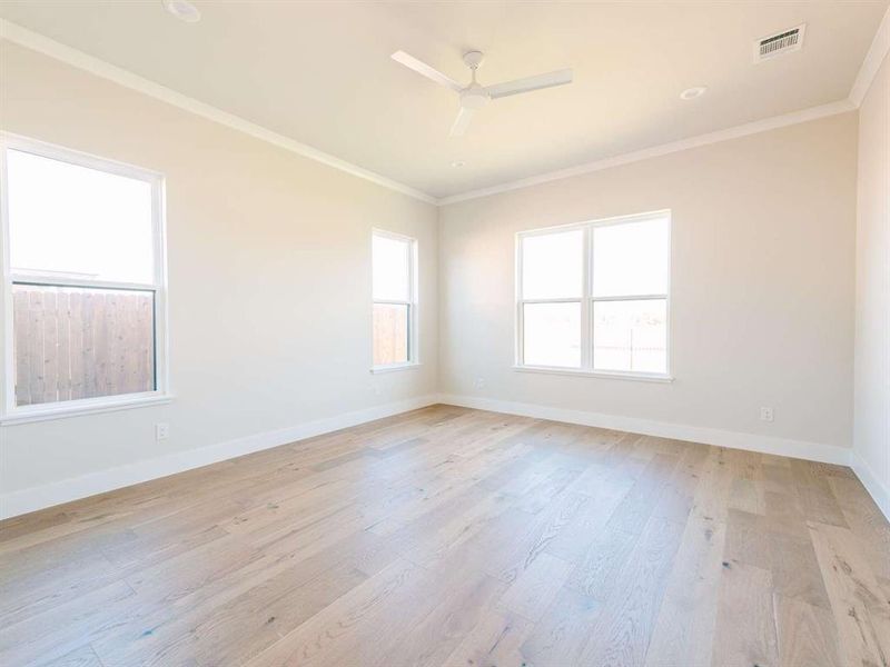 Empty room with ornamental molding, light hardwood / wood-style flooring, and ceiling fan