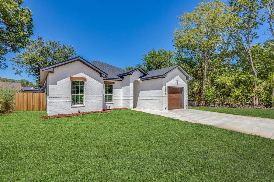 View of front of property with a garage and a front lawn