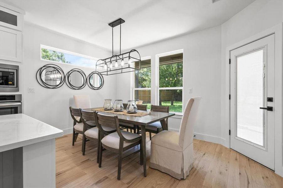 Dining space with light hardwood / wood-style flooring and a chandelier