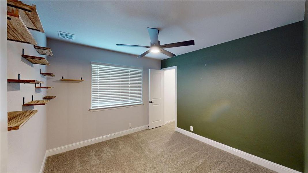 Carpeted spare room with ceiling fan