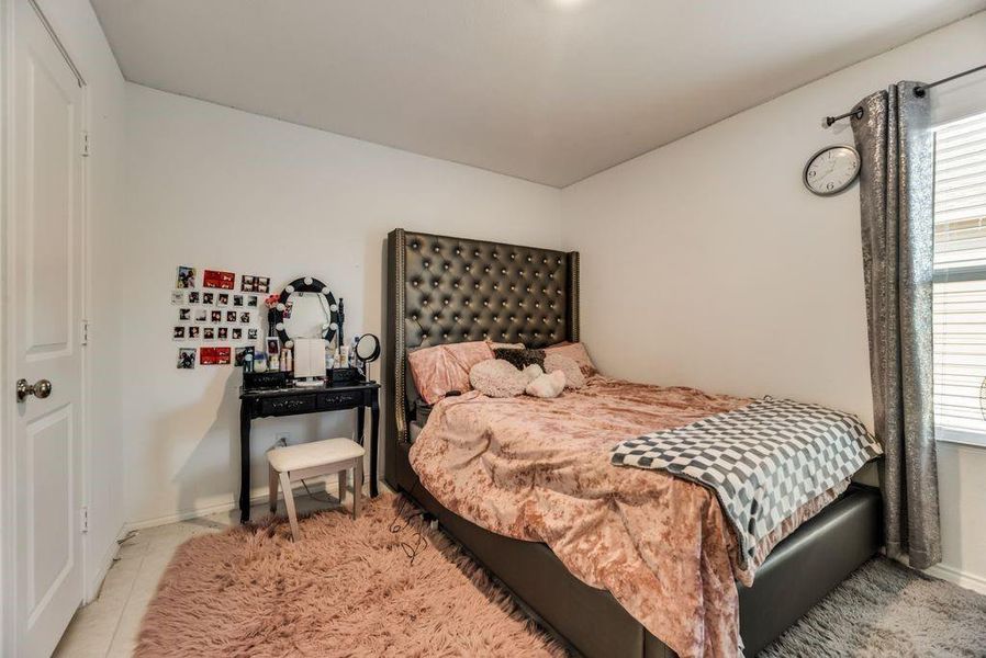 Bedroom featuring light tile patterned floors and multiple windows