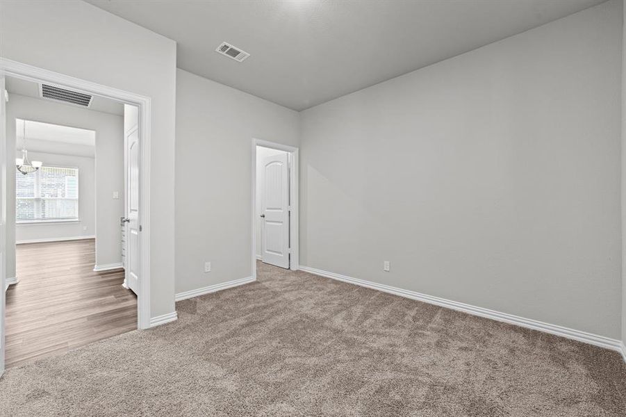 Unfurnished bedroom featuring wood-type flooring and an inviting chandelier