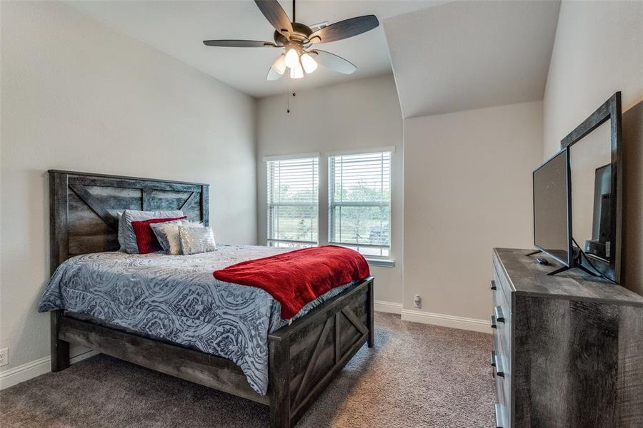 Bedroom with carpet, vaulted ceiling, and ceiling fan