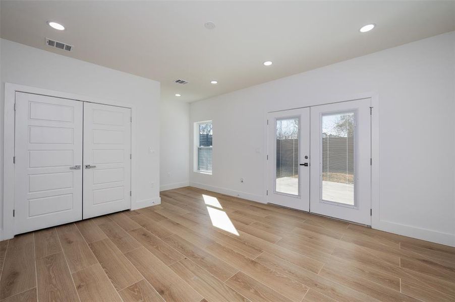 Unfurnished bedroom with french doors, a closet, light wood-type flooring, and access to exterior