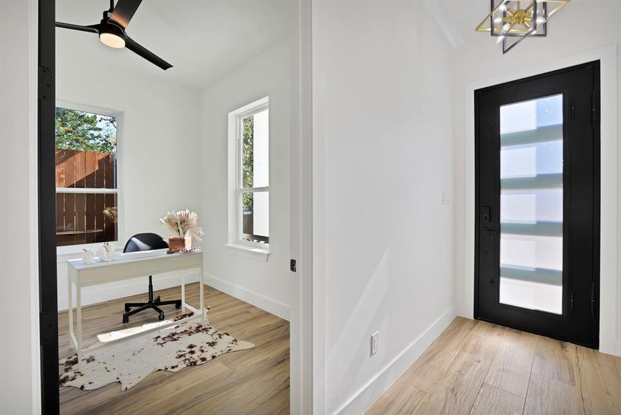 Office featuring plenty of natural light, light hardwood / wood-style floors, and ceiling fan with notable chandelier