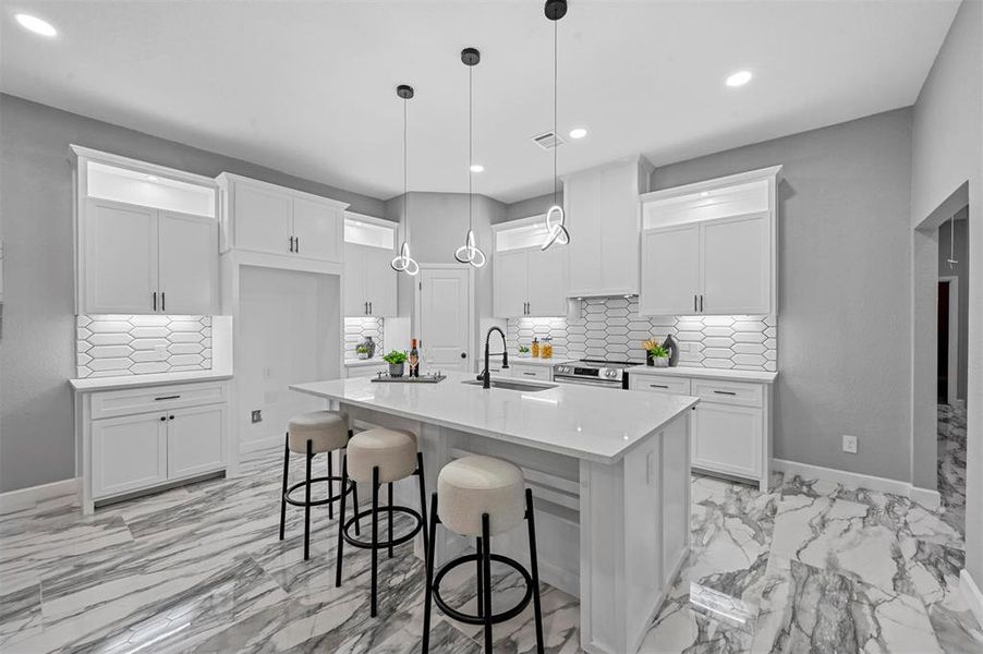 Kitchen with a kitchen island with decorative light fixtures and under-cabinet lighting