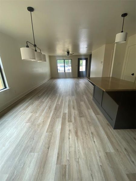 Unfurnished living room featuring light hardwood / wood-style floors and ceiling fan