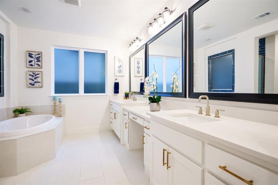 Bathroom with vanity, a relaxing tiled tub, and tile patterned flooring