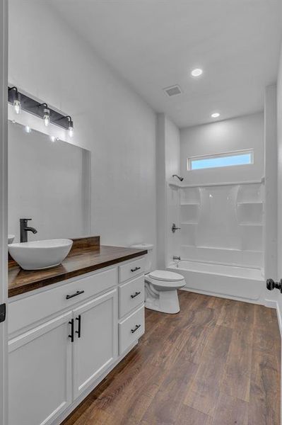 Full bathroom featuring vanity, wood-type flooring, toilet, and shower / bathtub combination