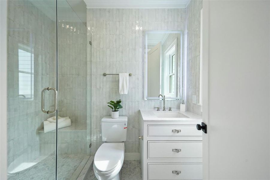 Elegance at its best in this downstairs in-law suite full bathroom with its pristine glass shower, and sleek vanity design.