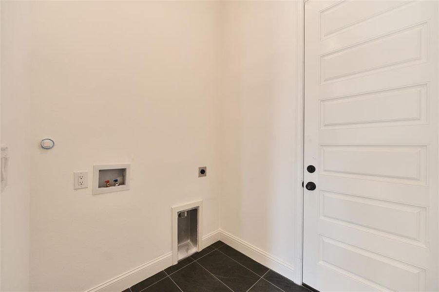 Clothes washing area featuring washer hookup, electric dryer hookup, and dark tile patterned floors