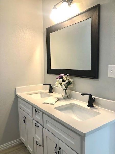 Bathroom with vanity with extensive cabinet space and double sink