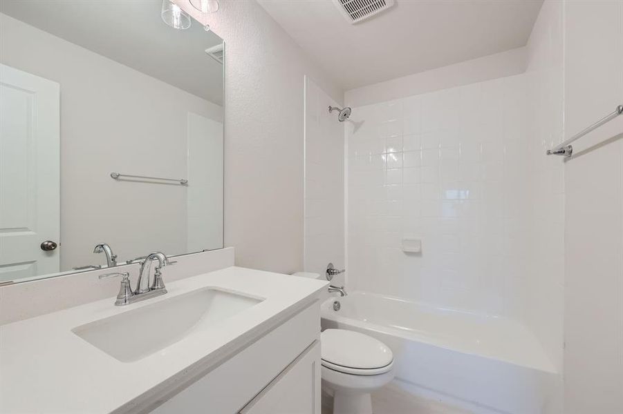 Full bathroom with vanity, toilet, and tiled shower / bath