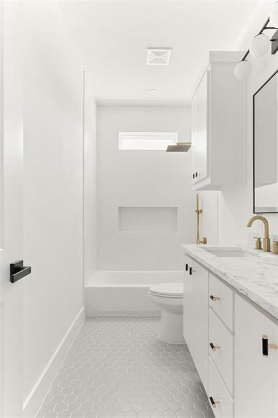 Full bathroom with vanity, toilet, tile floors, and tub / shower combination