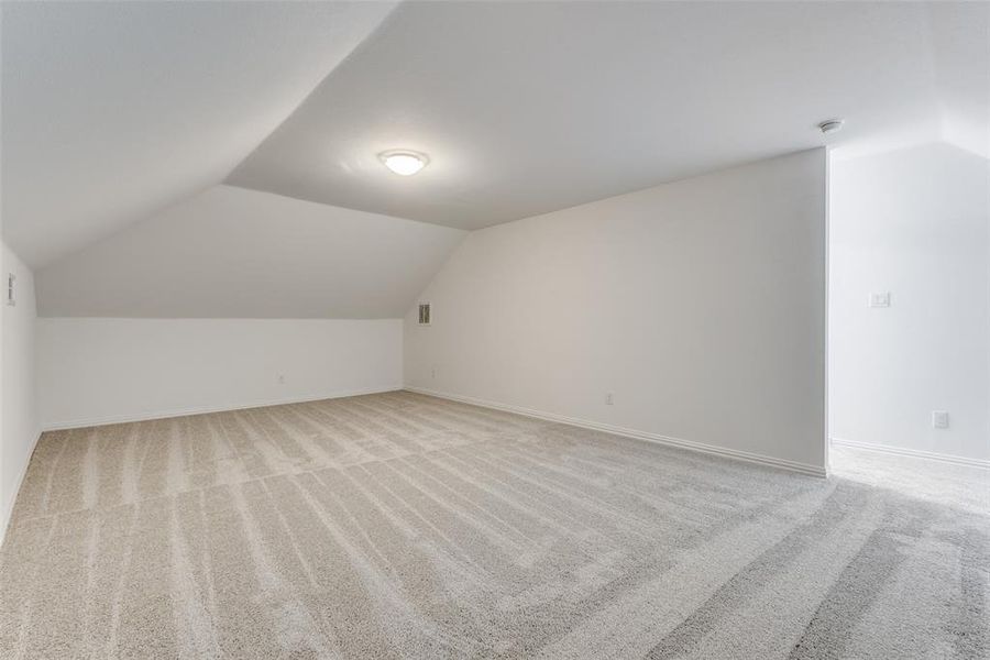 Bonus room featuring light carpet and lofted ceiling