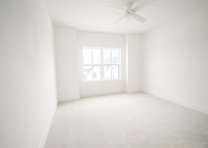 Carpeted spare room featuring ceiling fan