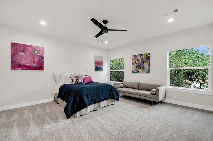 Carpeted bedroom featuring ceiling fan