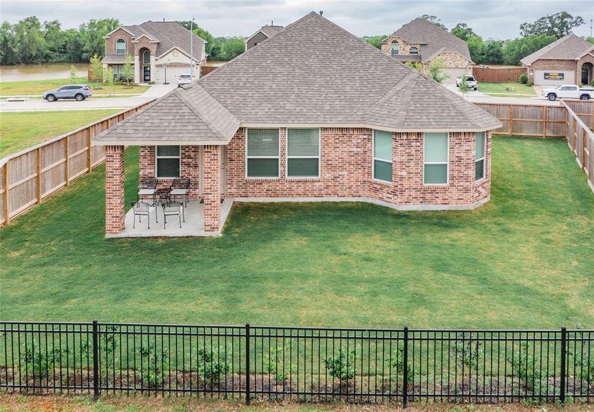 aerial of the rear with a covered patio , all brick home and you can see the lake across the street.