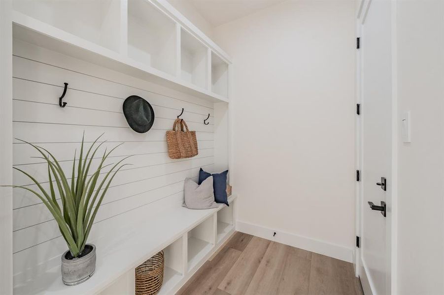 Mudroom featuring blonde plank, wood-like luxury vinyl floors.