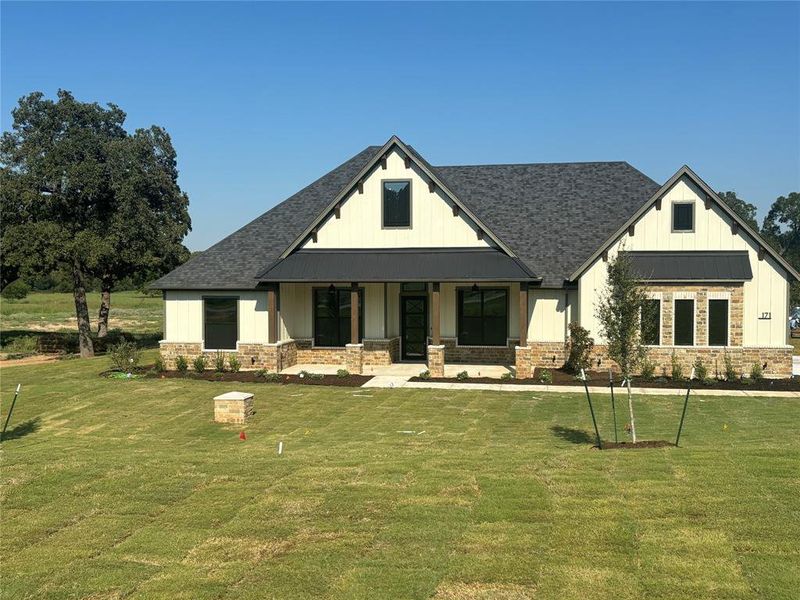 View of front of home with a porch and a front lawn