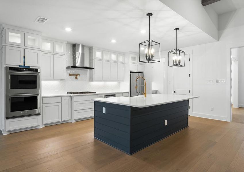 The kitchen has a beautiful blue island with quartz countertops.