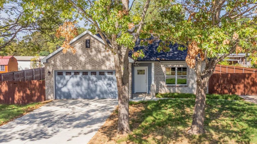 View of front of home featuring a front yard and a garage